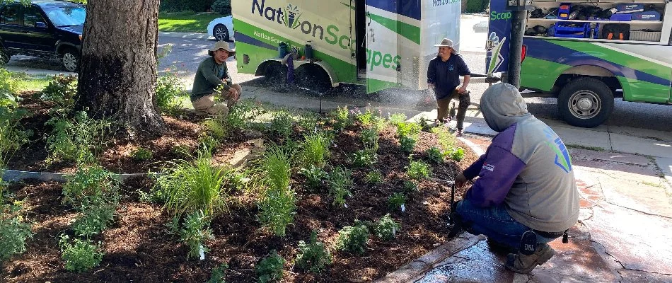 Three crew members working on an irrigation system on a property in Denver, CO.