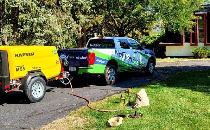 Company truck with attached sprinkler compressor in Denver, CO.